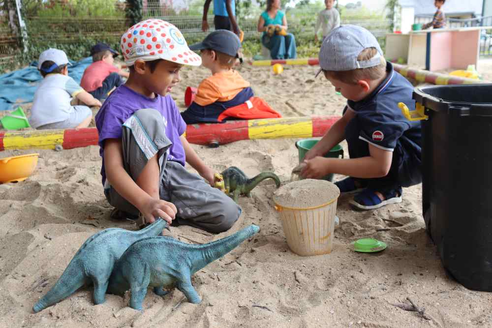 deux enfants jouent dans un bac à sable